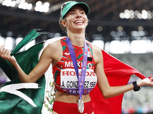 La marchista Alegna González, formada en Baja California Sur, celebrando con la bandera de México tras ganar la medalla de plata en el Mundial de Atletismo de Tokio.