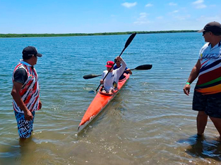 El equipo de canotaje K4 de Baja California Sur remando en perfecta sincronía durante una competencia en una pista olímpica.