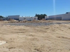 Panoramic view showing the contrast between resort developments and the rapid growth of urban settlements on the hills of Los Cabos.