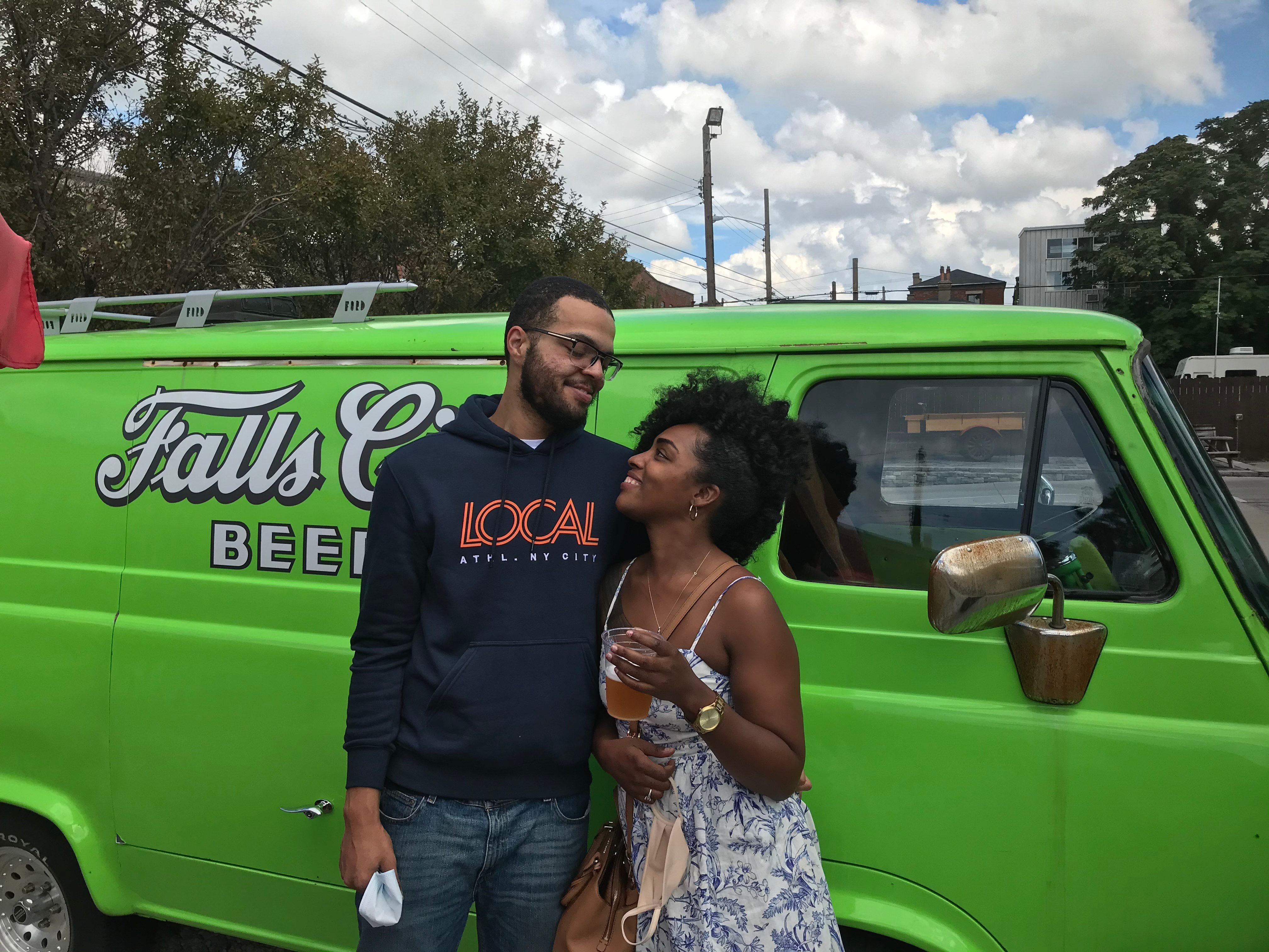 couple standing in front of a green bus