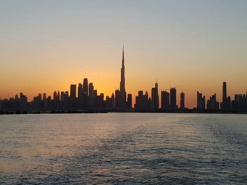 A city skyline seen across water at sunset
