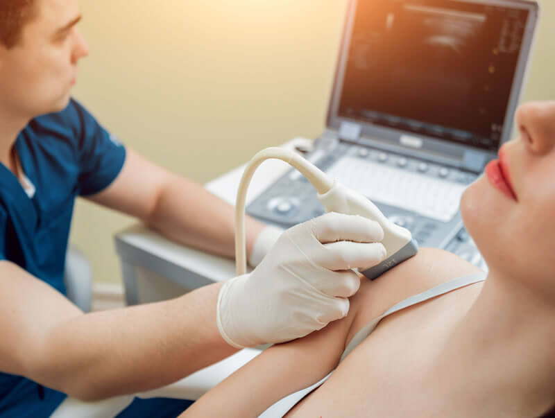 Clinician performing musculoskeletal ultrasound for sports medicine evaluation.