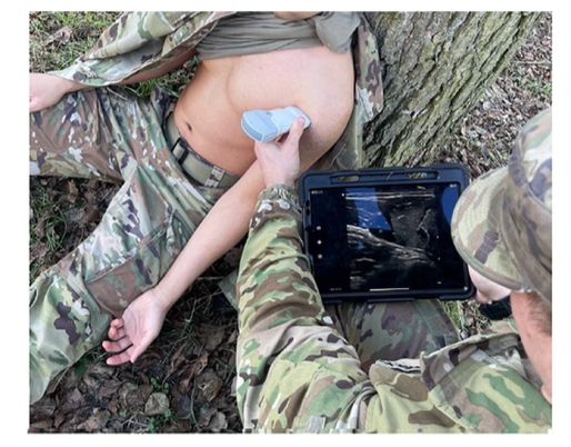 Physical therapist using handheld musculoskeletal ultrasound in a field environment to evaluate a musculoskeletal injury at the point of care.