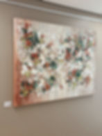 Abstraktes Acrylgemälde mit floralen Formen in warmen Erdtönen und Weiss, an einer Wand ausgestellt.