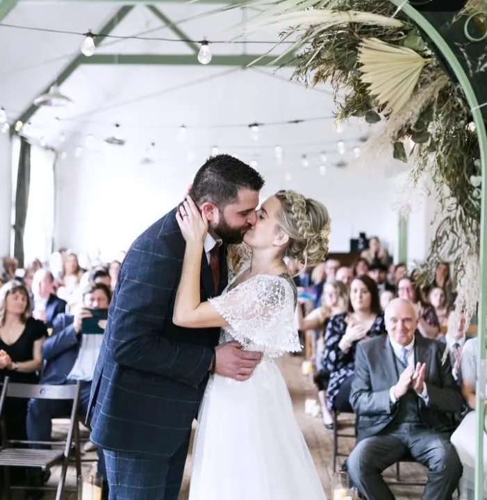 bride and groom kissing at the aisle