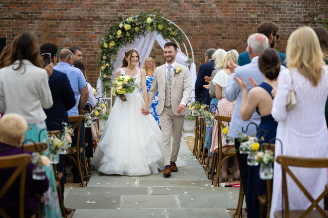 bride and groom walking down the aisle holding hands