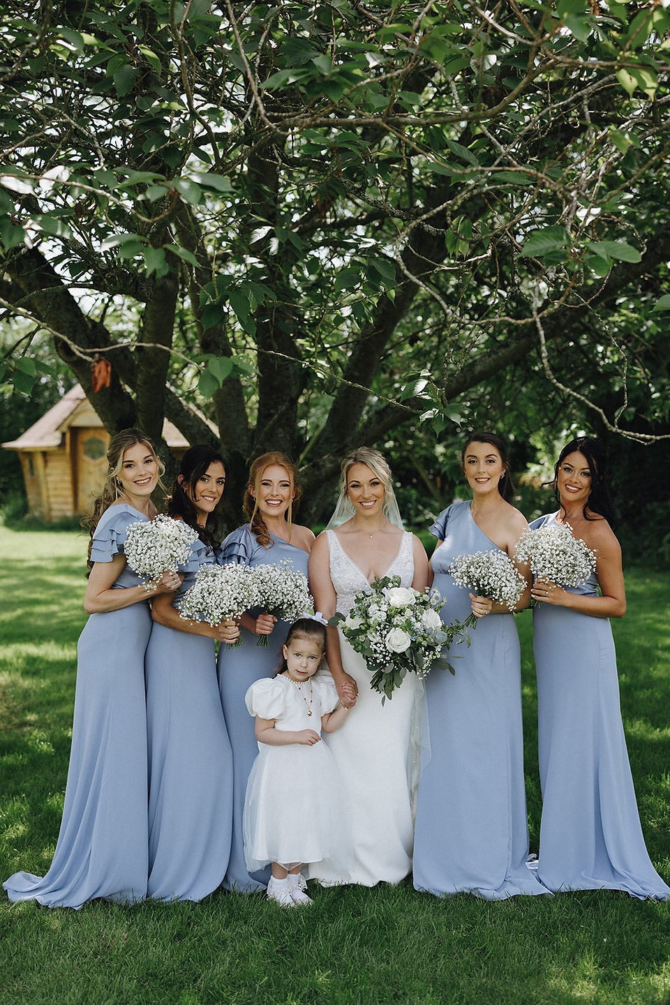 bride with her bridesmaids who are wearing blue