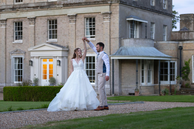 bride and groom dancing outside manor house