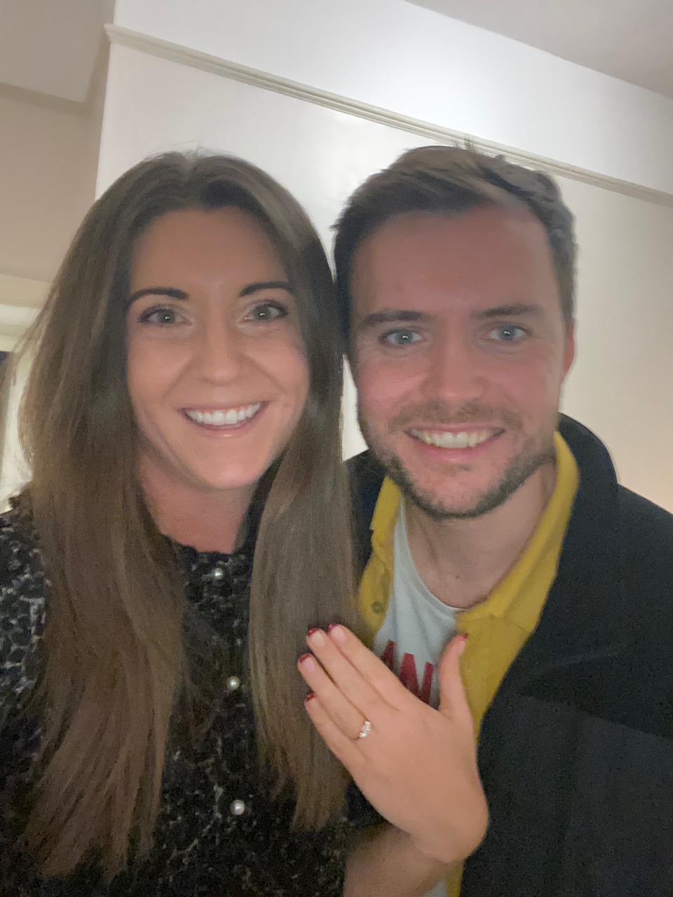 women smiling with engagement ring on her finger 