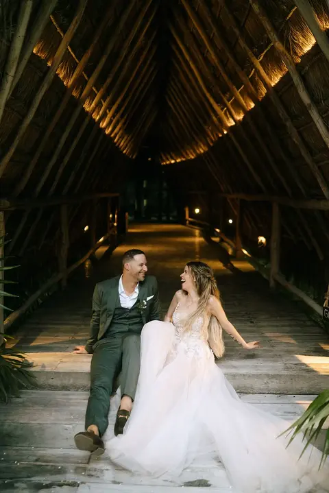 Bride and groom seated at jungle destination wedding reception in Tulum