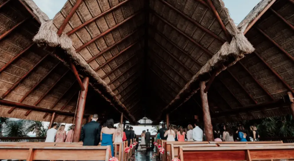 Seamless destination wedding ceremony in a palapa-style iglesia, Riviera Maya.
