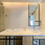 Miniatura: Bathtub with beige tile surround and window for natural light.