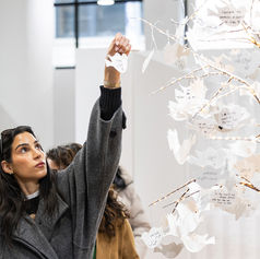 Visitor placing a note on the wish tree at Pomexpo Norooz Bazaar