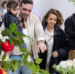 Family exploring Haft-Seen display at Pomexpo Norooz Bazaar in New York City