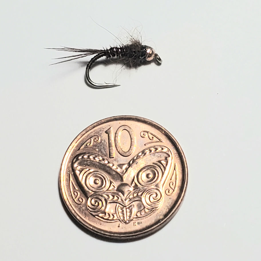 Close-up fishing nymph fly: Brown possum dubbing body, brown pheasant tail tied on a #12 or #16 grub hook with coin