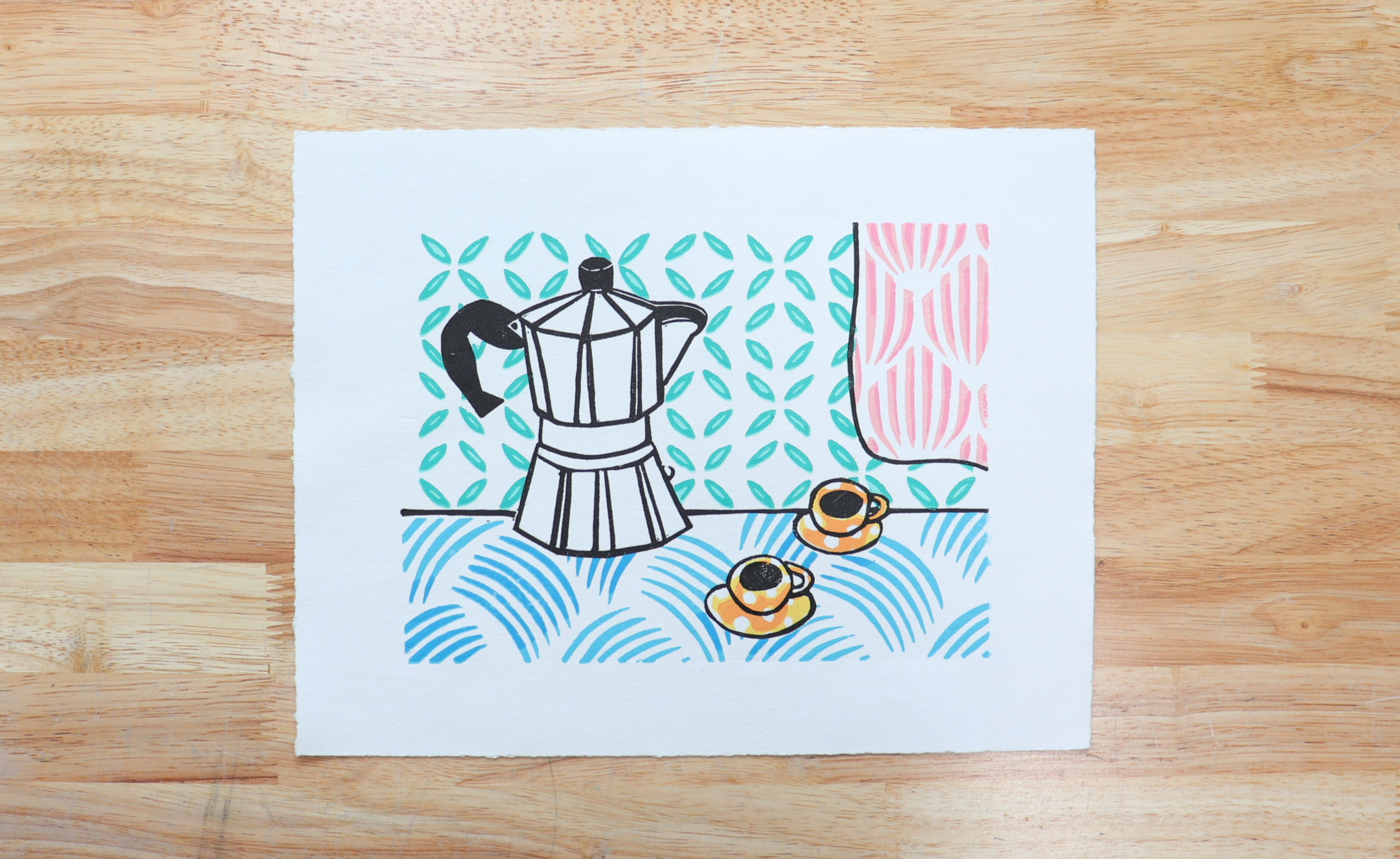 handmade multi color relief print of a moka pot and two espresso cups in a colorful kitchen