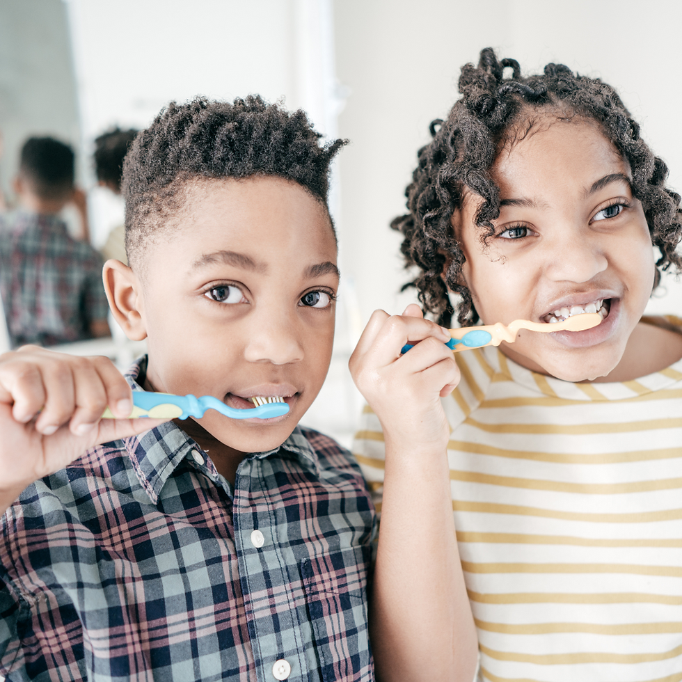 Two young children brushing their teeth together, building routines that support raising organized kids with habits and systems for daily success.