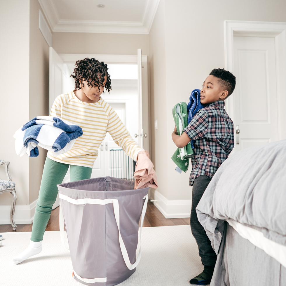 Brother and sister putting away laundry together, practicing household responsibilities and raising organized kids with habits and systems.
