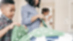 Brother and sister putting laundry into a hamper — raising organized kids through shared household chores.