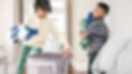 Mother teaching children to fold laundry together — raising organized kids through daily routines.