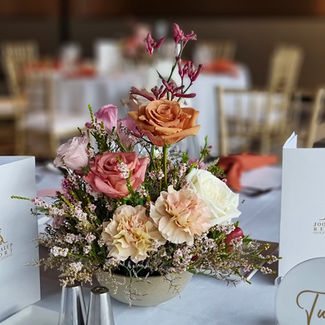 Pink and peach rose centrepiece on wedding reception table