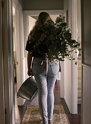 Behind the scenes carrying fresh greenery during wedding flower preparation