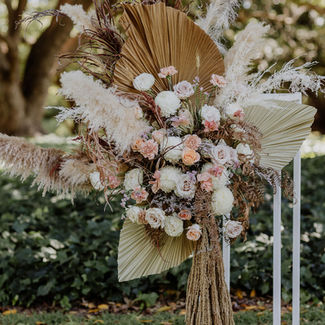 Dried palm frond and pampas grass arrangement with blush roses