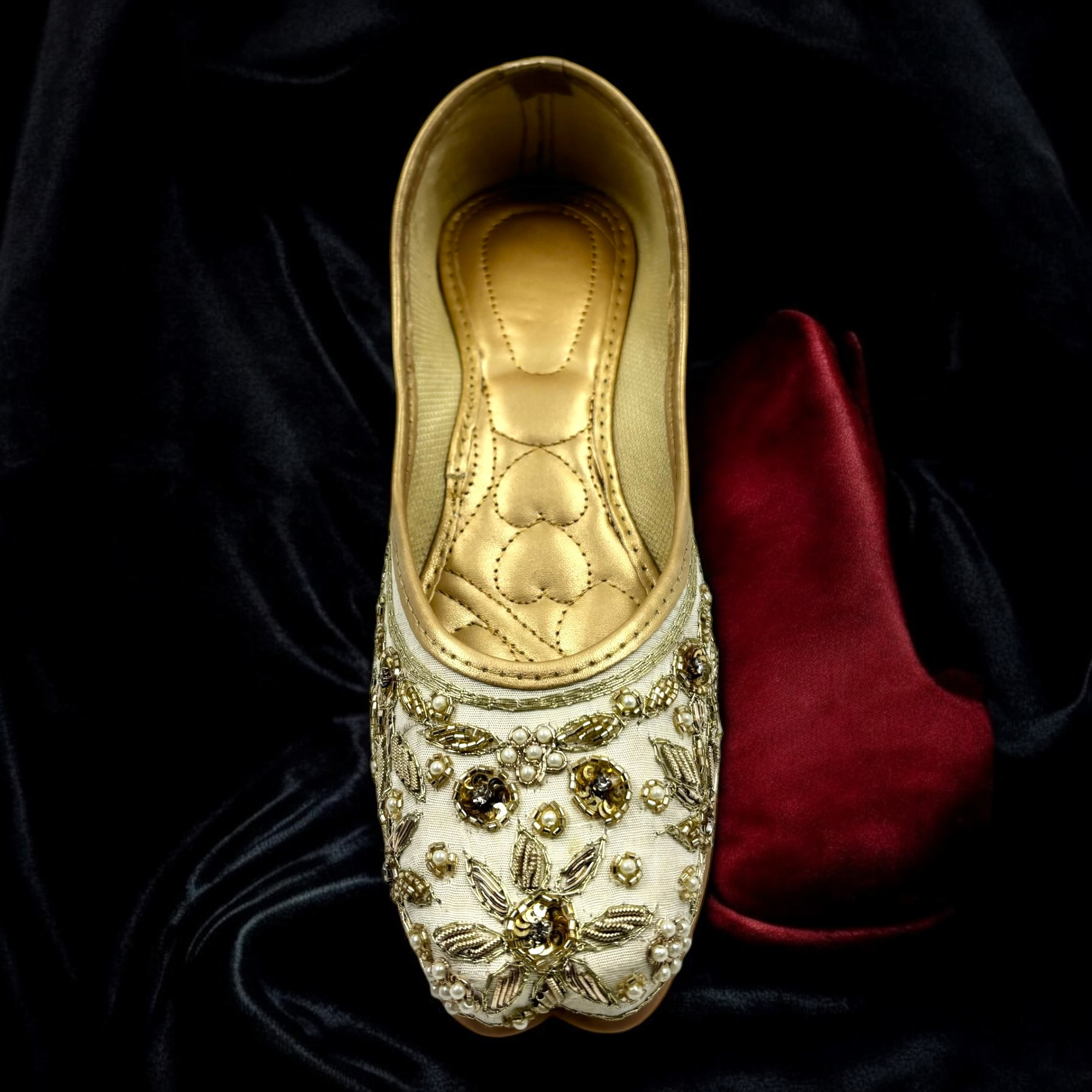 Creamy - White Punjabi Jutti with golden embellishments.
