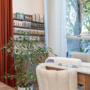Modern nail salon station with white chair and polish shelf