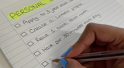 hand writing out list of personal goals onto paper