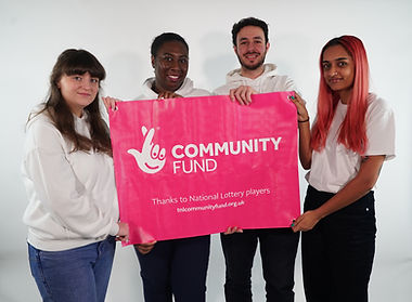 Open Lens Media team holding large Community Fund banner
