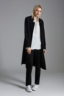 a woman wearing a black coat and a white shirt