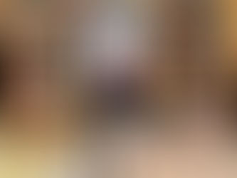 An author filming herself with an iPad on a tripod, standing in front of a large wall of bookshelves