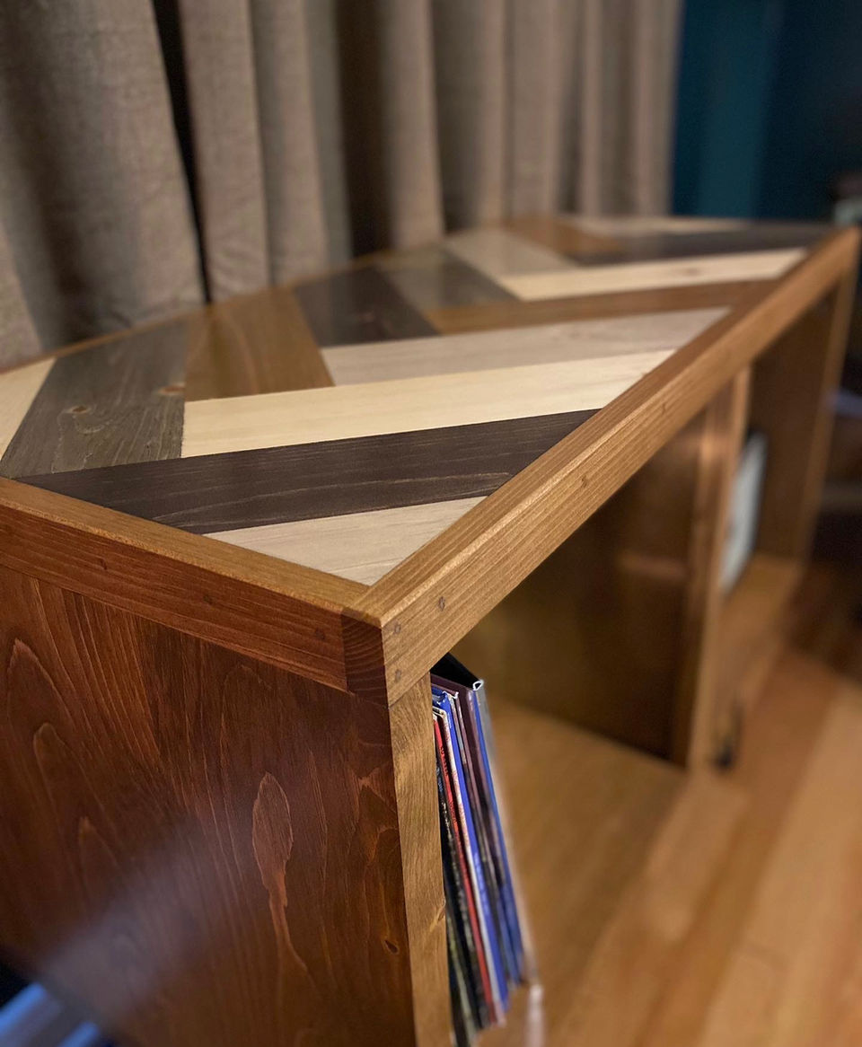 Custom record storage cabinet with herringbone pattern and natural wood tones 