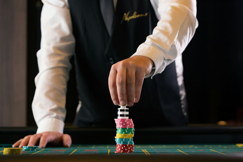 napoleons casino dealer in black waistcoat with gold embroidery