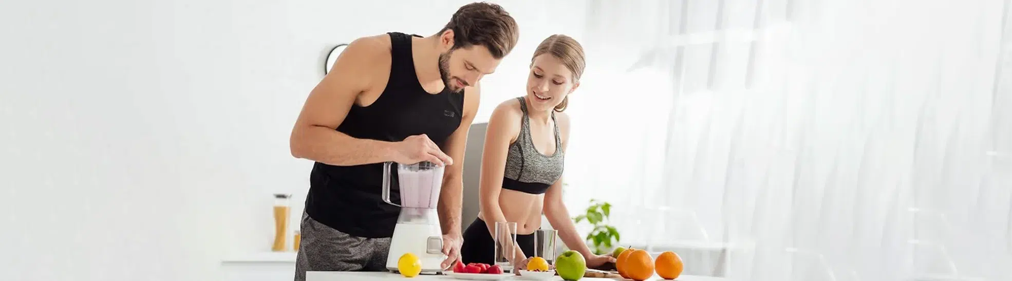 Sportive man preparing smoothie near happy girl and fruits good nutrition copy