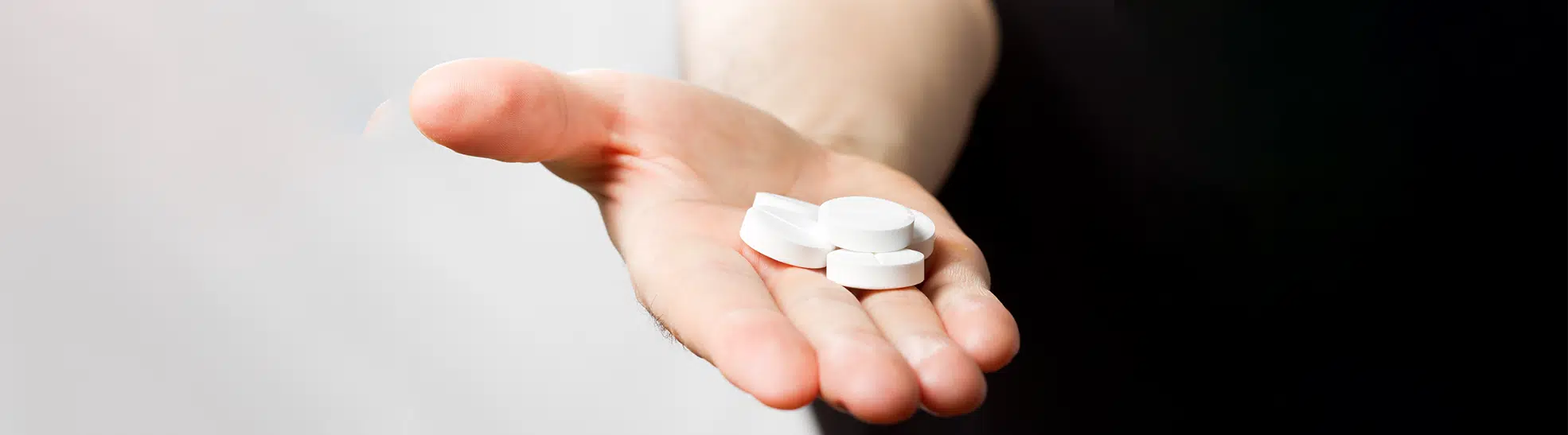 Man holding pills in palm. Close up