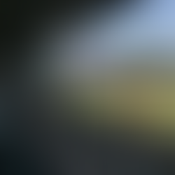 A baseball stadium with an empty seating area. The big screen shows two smiling men. Players warm up on the field. Signs and ads are visible.