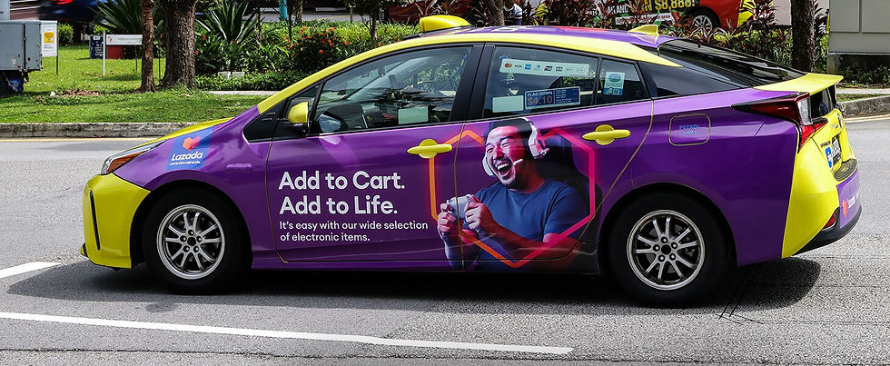 Purple and yellow taxi with Lazada ad. Text: "Add to Cart. Add to Life." Image of a person gaming. Street scene with trees.