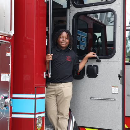 Mentee from Kut Different posing with a fire truck
