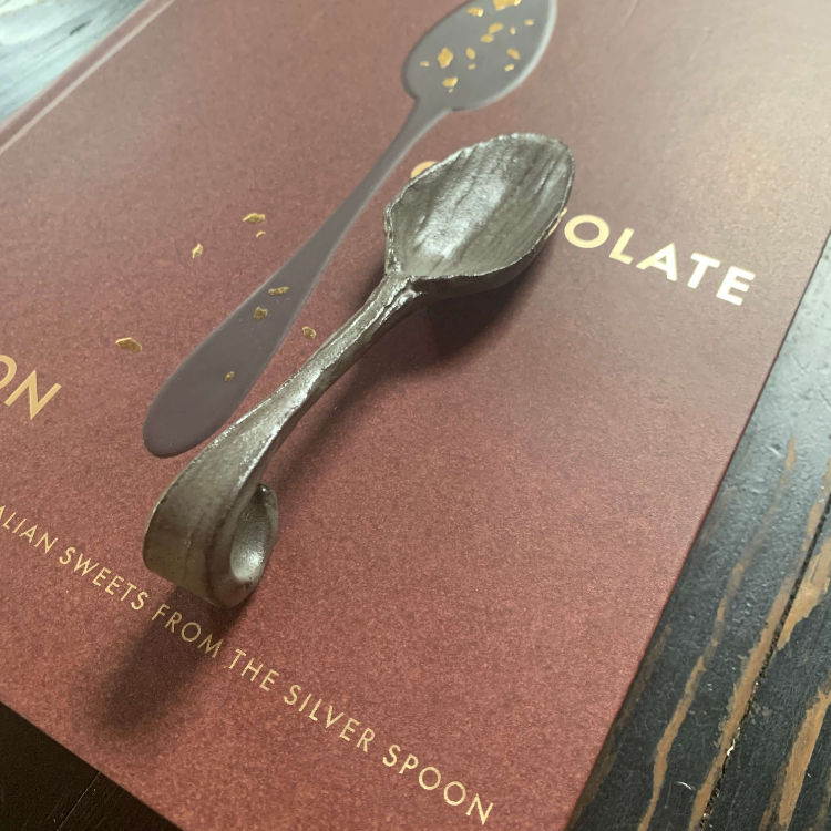 Thumbnail: Handmade Pottery spoon resting on the cove to The Chocolate Spoon Cookbook