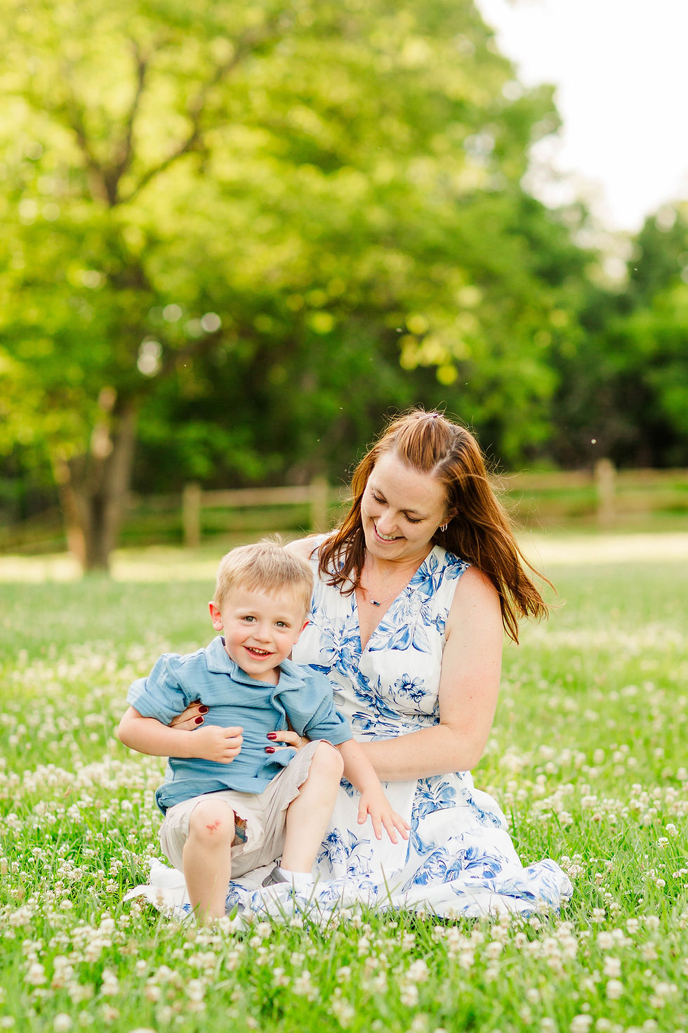 Mother and son in grass, smiling.