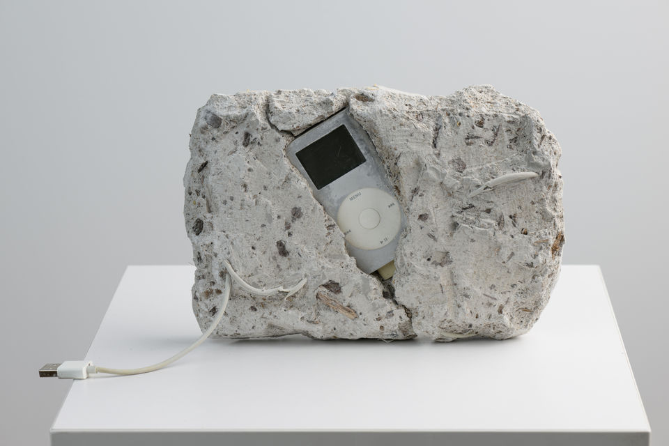Installation view of Archive of Digital Portraits Cast in Concrete by Blair Simmons at THE BLANC, featuring concrete sculptures embedded with electronic remnants representing digital identities.