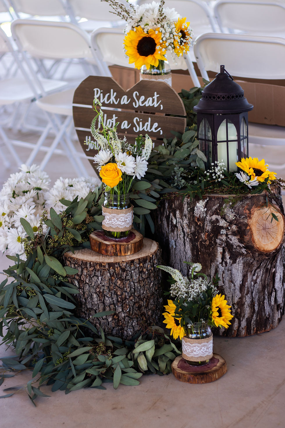 a floral arrangement outside a venue consisting of white flowers and wooden rental decor