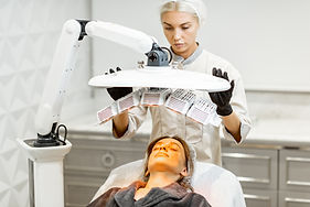 Young woman doing led light therapy on her face with a doctor at luxury medical office.jpg