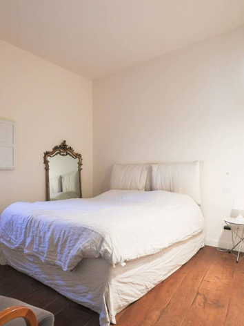 Open space moderno a Bologna con soggiorno, cucina e tavolo da pranzo, arredamento su misura e pavimenti in parquet. appartamento centro bologna elegante e moderno.