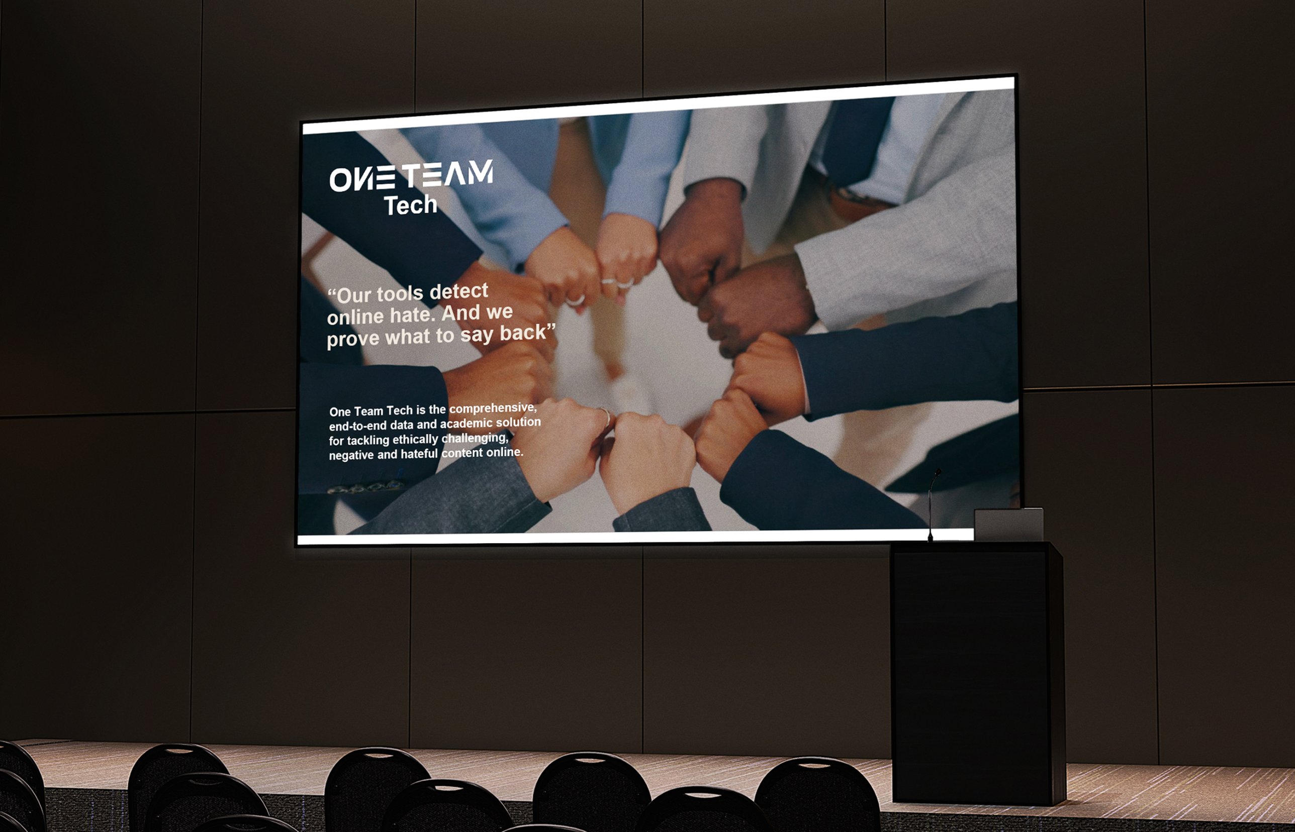 One Team Tech pitch deck title slide on a large screen in a conference room