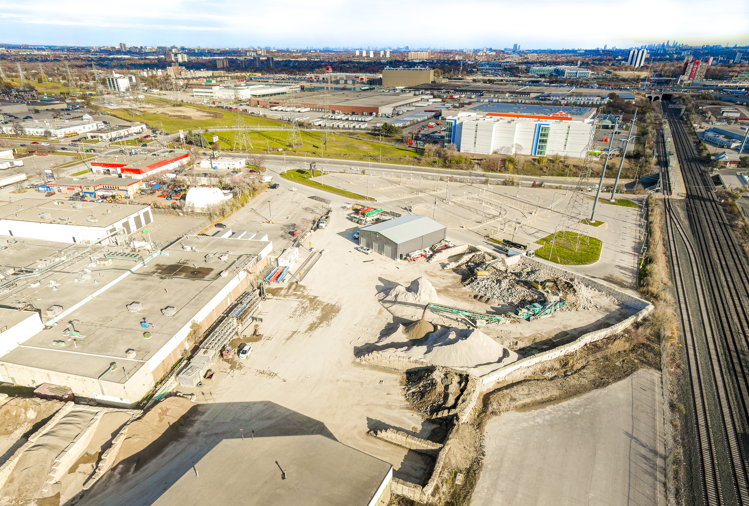 Aerial view of the JCL and OTD yard in Toronto with aggregate stockpiles, material recovery areas, trucks, and heavy equipment.