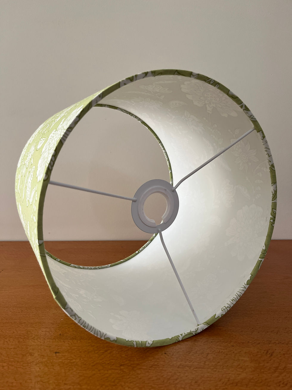 Interior of green and white floral lampshade showing white PVC lining.