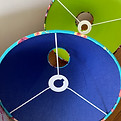 A photo of two colourful lampshades in blue and green colour schemes.